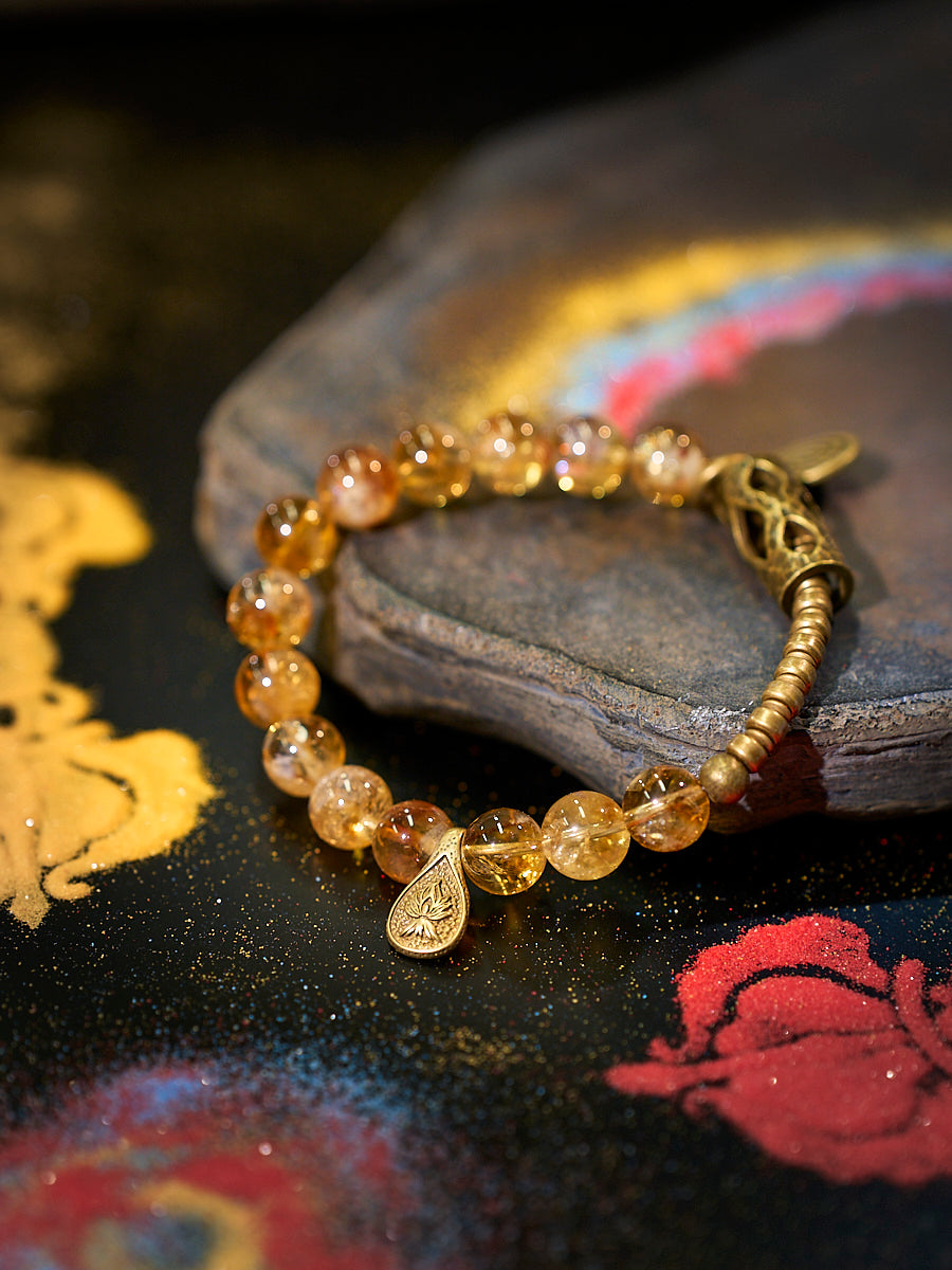 Bracelet with amber-colored beads and gold accents on a decorative surface
