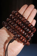 Source-described old sliced phoenix eye bodhi 108 bead mala held in hand