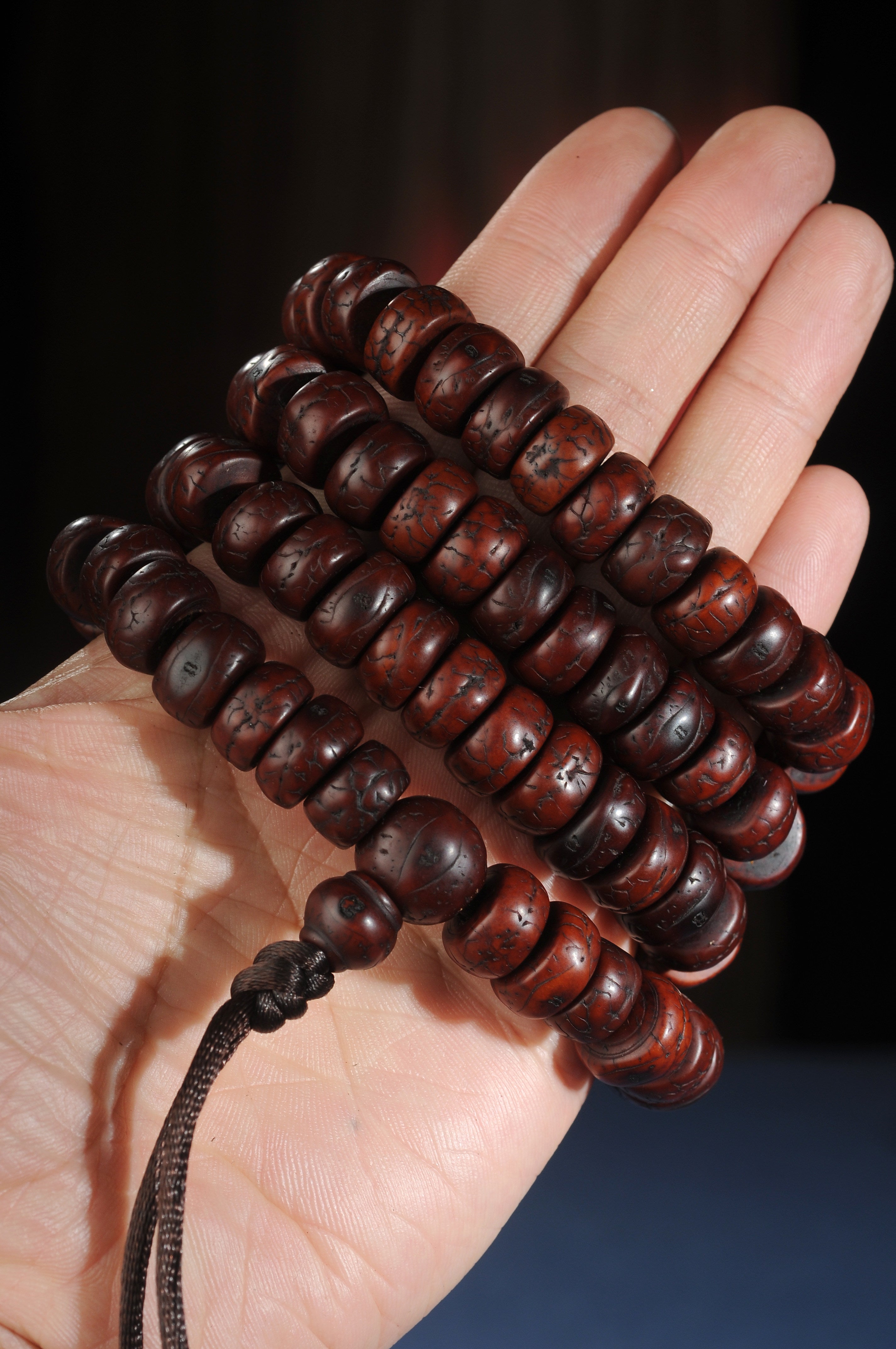 Source-described old sliced phoenix eye bodhi 108 bead mala held in hand