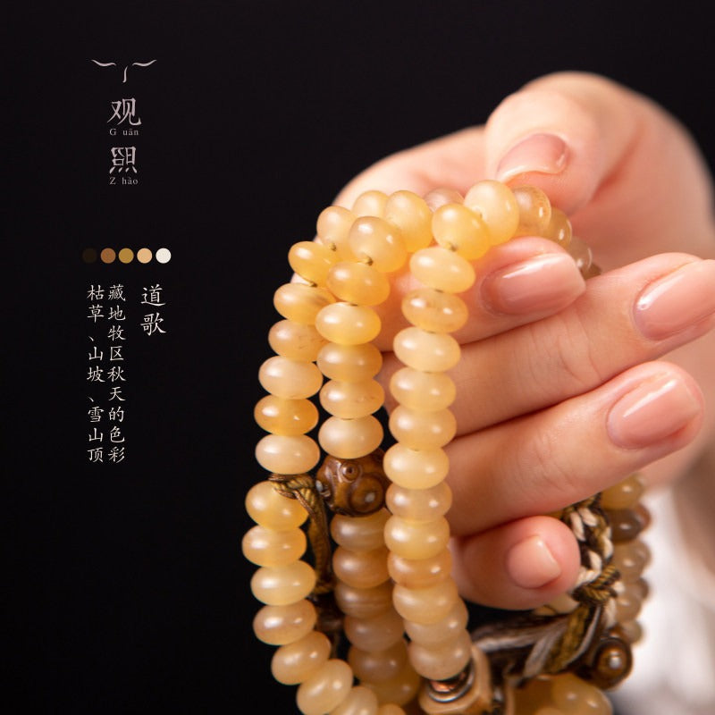 Daoge sheep horn 108 mala with honey-yellow beads held in hand