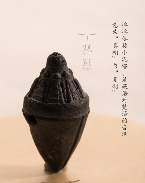 Close product portrait of charcoal-black tsatsa pendant