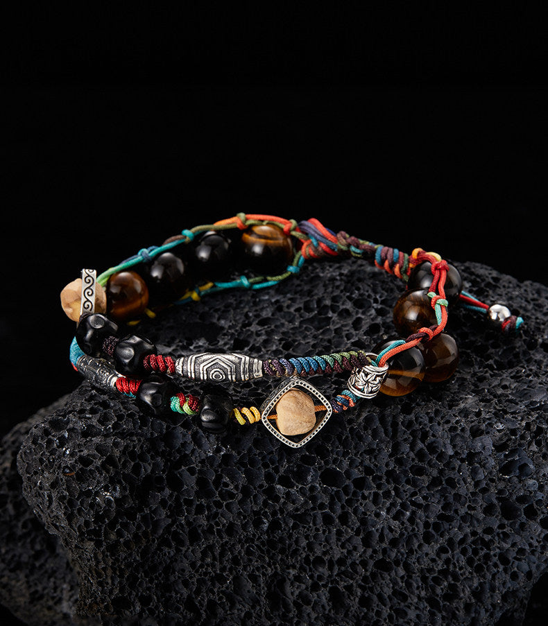 Woven tiger eye and seed bead bracelet shown on dark textured background