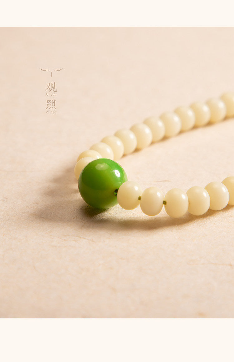 Close detail of white bodhi beads and green accent bead