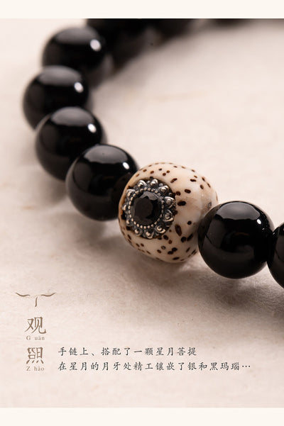 Close detail of black agate bracelet with star-moon bodhi inlay focal bead