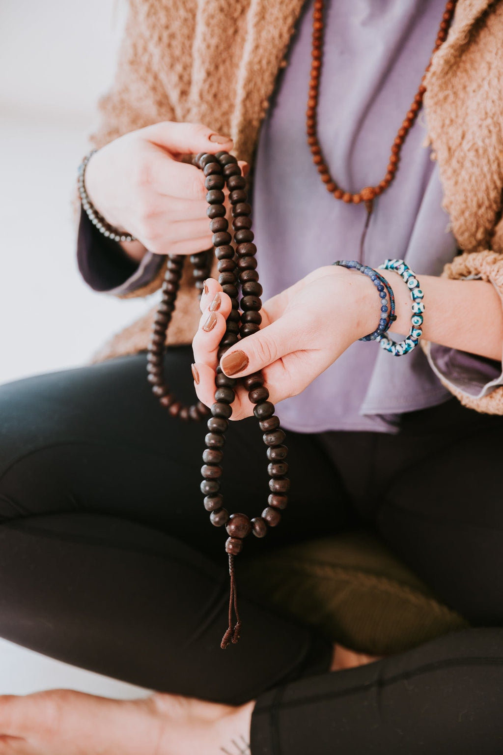 Dark bodhi seed 108 mala held during seated meditation
