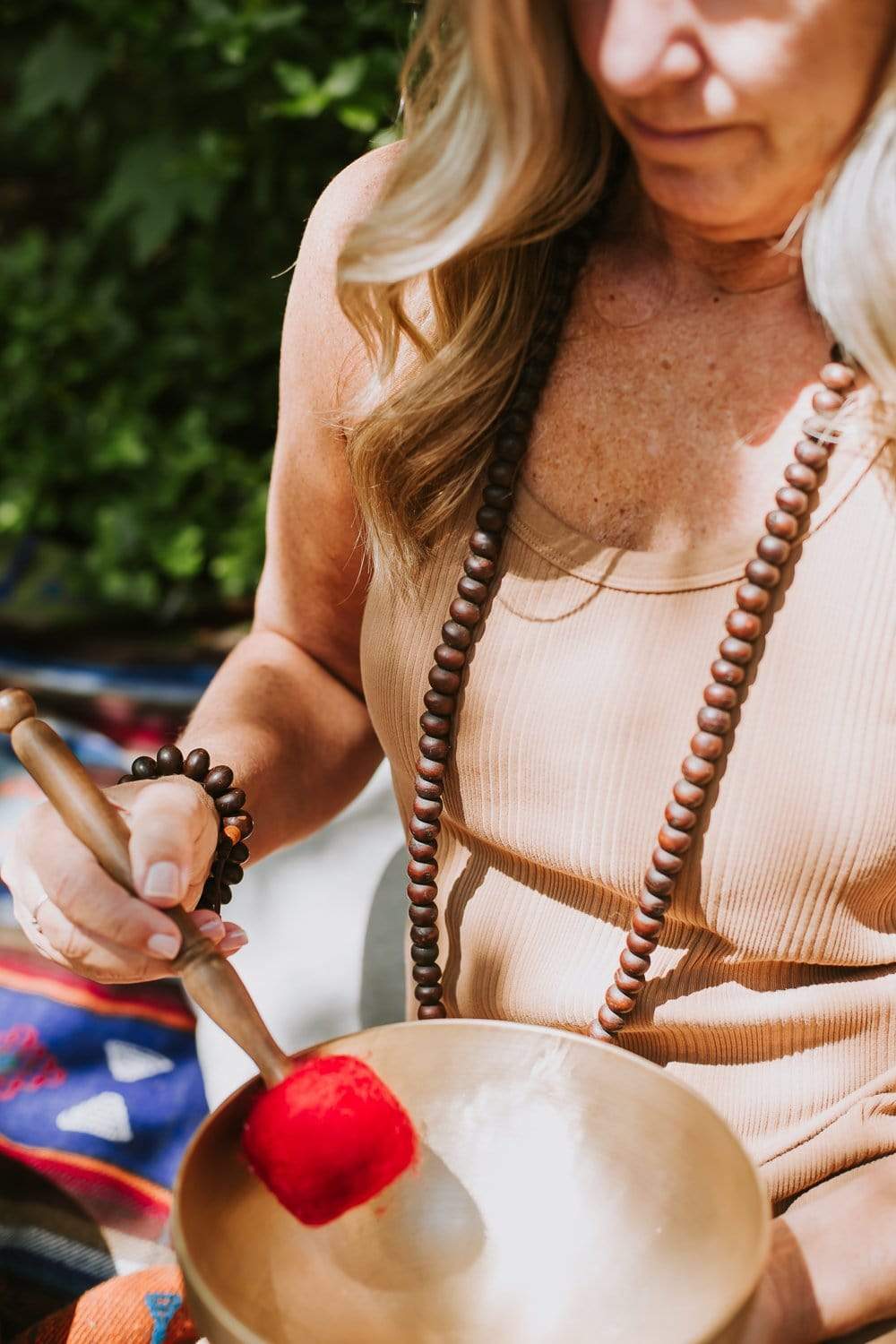 Long dark bodhi seed mala worn while using a singing bowl