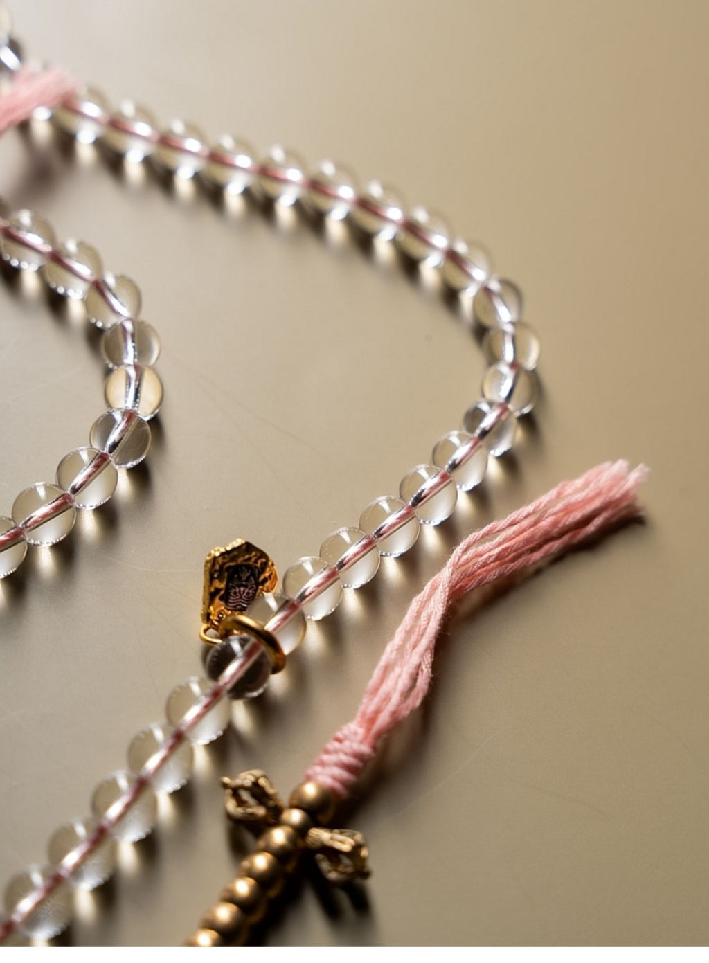 Close view of white crystal beads and warm metal mala accents