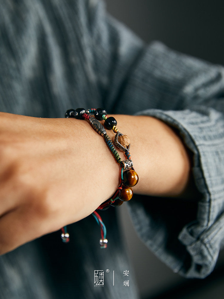 Close lifestyle view of woven bracelet with silver-tone and tiger eye details
