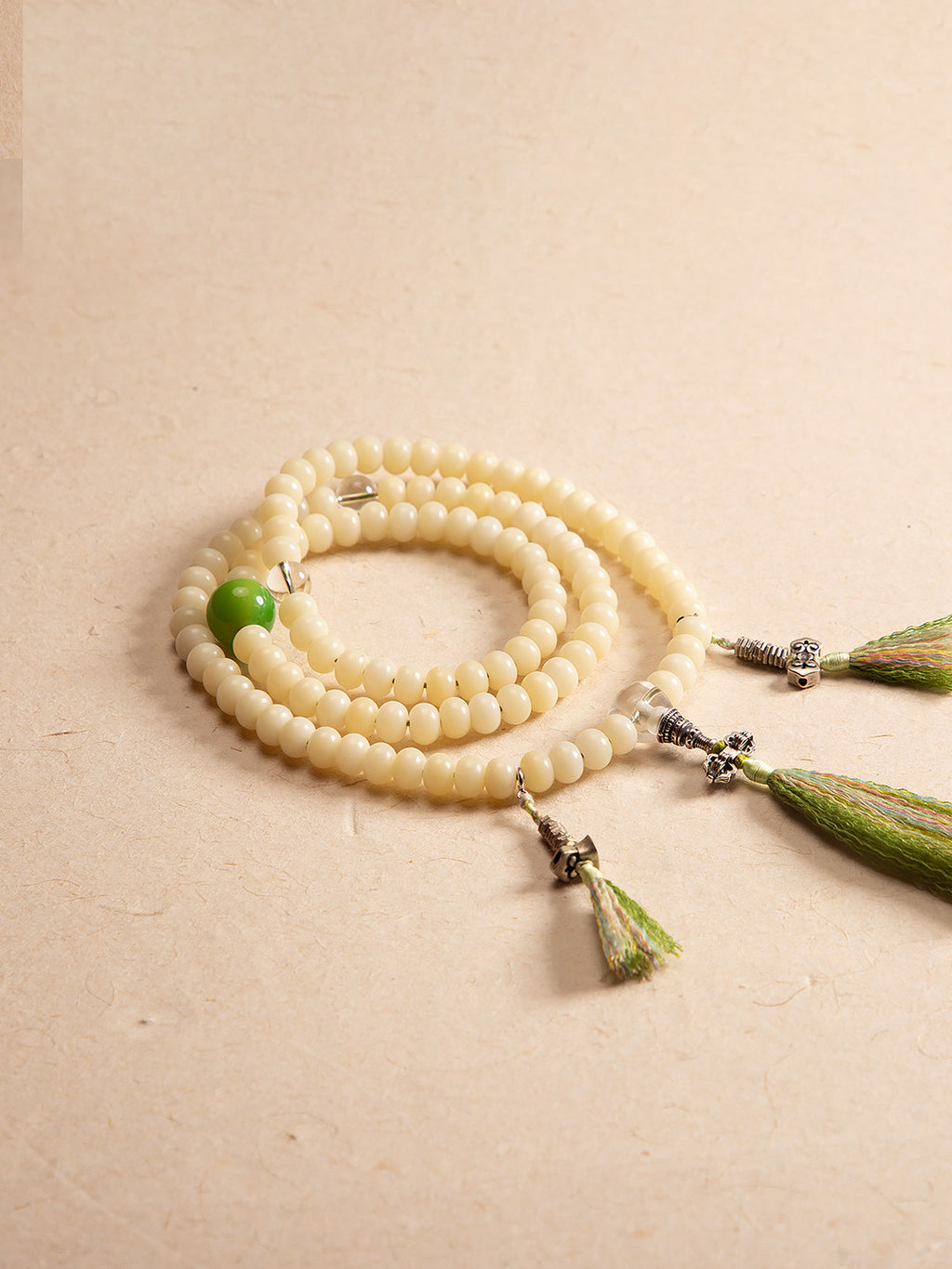 White bodhi 108 mala laid flat on warm neutral background