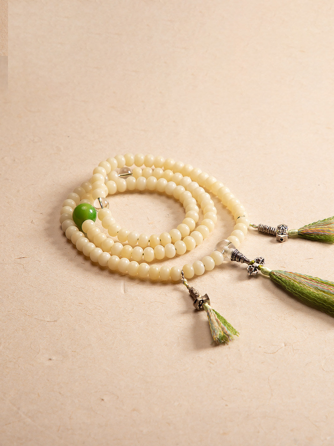 White bodhi 108 mala laid flat on warm neutral background