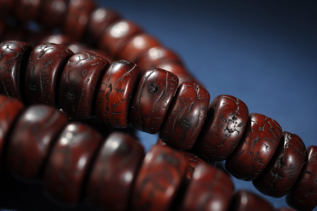 Close detail of dark red-brown sliced bodhi seed mala beads