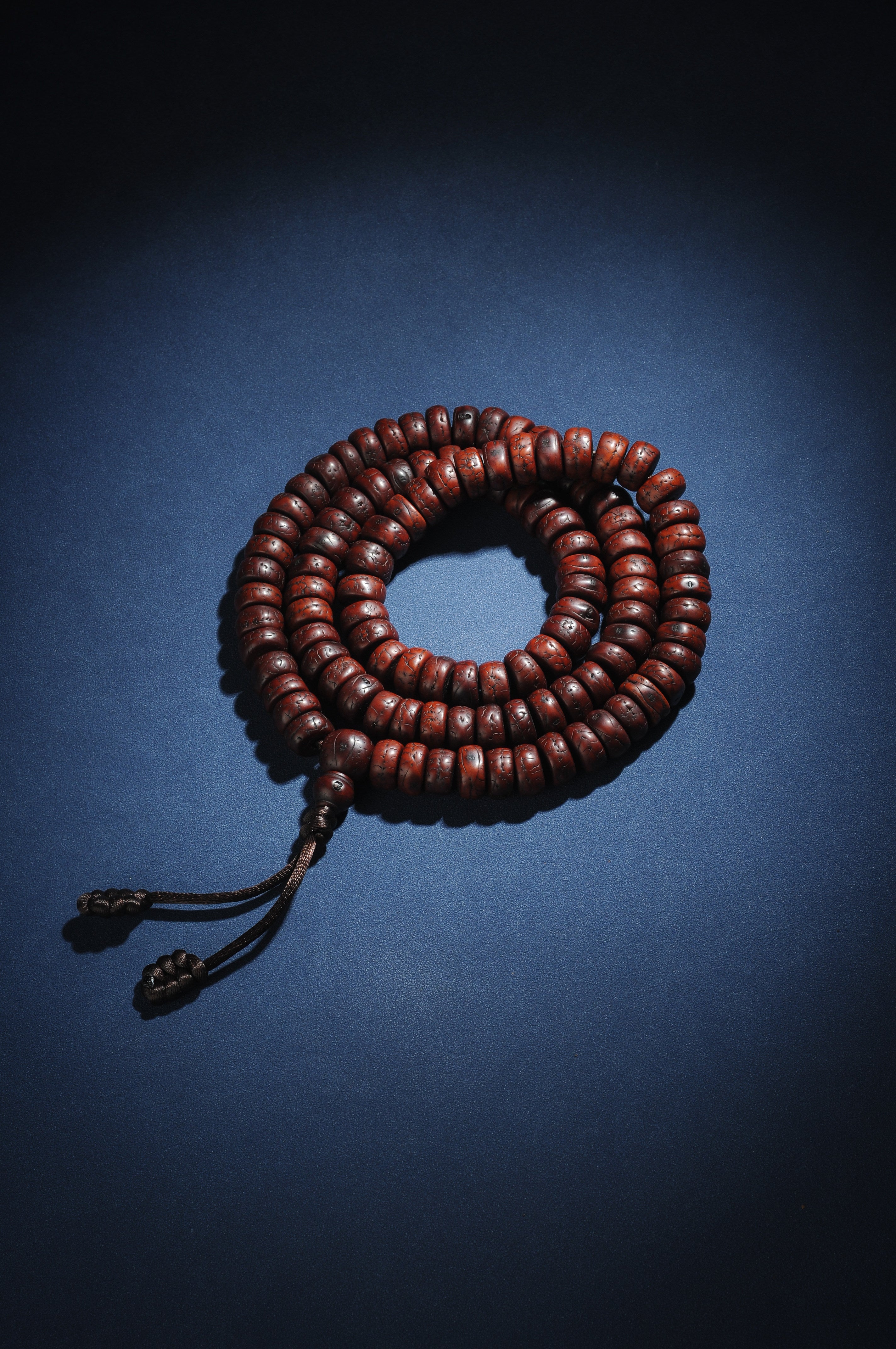 Full coiled red-brown sliced phoenix eye bodhi mala with dark cord